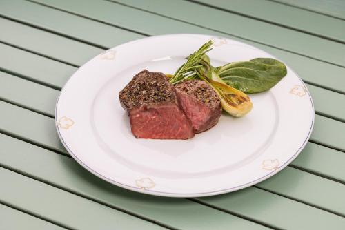 a plate of meat and vegetables on a table at Vitalia Seehotel in Bad Segeberg
