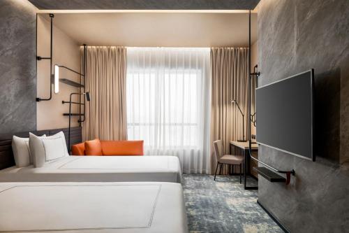 a hotel room with two beds and a tv at Novotel Residences Makkah in Makkah