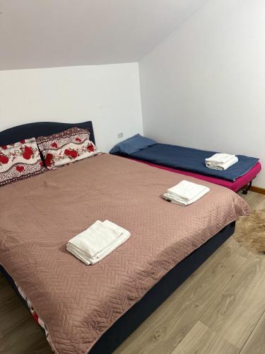 a bedroom with a bed with towels on it at Cabana Irina Băile Figa in Beclean