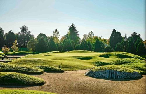 un exuberante campo de golf verde con árboles en el fondo en Magnifique 3 étoiles 10 min de Disney et 40 min de Paris, en Bailly-Romainvilliers