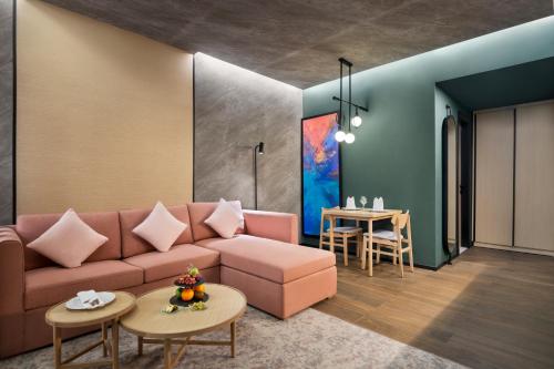 a living room with a pink couch and a table at Novotel Residences Makkah in Makkah
