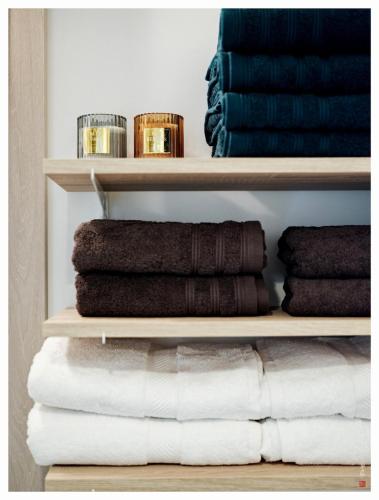 une pile de serviettes sur les étagères d'une pièce dans l'établissement Magnifique 3 étoiles 10 min de Disney et 40 min de Paris, à Bailly-Romainvilliers