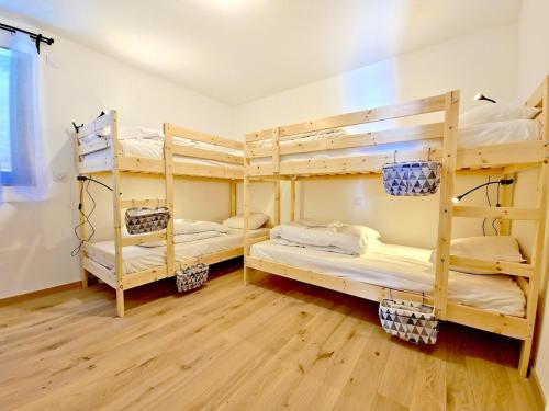 deux lits superposés dans une chambre avec parquet dans l'établissement Pépite! Neuf-Familial-Central, à L'Alpe-d'Huez