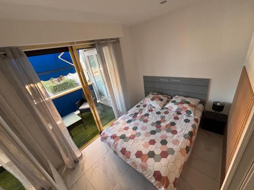 une petite chambre avec un lit et un balcon dans l'établissement Front de mer,plage, piscine, parking, à Cagnes-sur-Mer