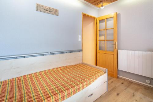 una camera da letto con un letto e una porta di legno di Les Echos des Cîmes - Pistes accessibles à pied a Villarembert
