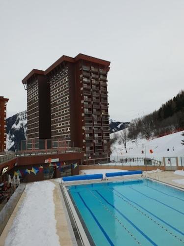une grande piscine devant un immeuble dans l'établissement Les Echos des Cîmes - Pistes accessibles à pied, à Villarembert