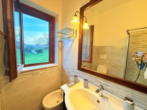 a bathroom with a sink and a toilet and a window at Smile in Manciano