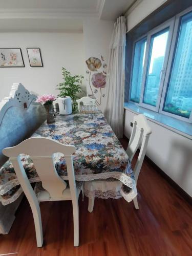 a dining room table with chairs and a floral table cloth at Yipinshiguang B&B in Harbin