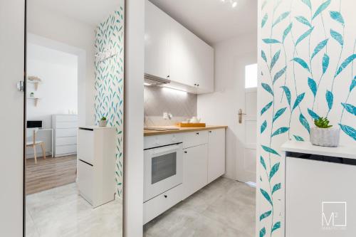 een keuken met witte kasten en blauw en wit behang bij Super Studio Oldtown in Gdańsk