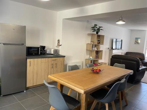 une cuisine et une salle à manger avec une table et un réfrigérateur dans l'établissement Gîte du Panda #Beauval #Châteaux, à Selles-sur-Cher