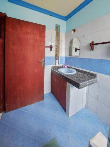 a bathroom with a sink and a red door at Azuri residence homestay in Mombasa