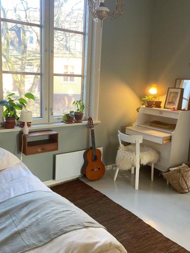una camera da letto con pianoforte e chitarra in una stanza di Iloinen taiteilijakoti a Turku