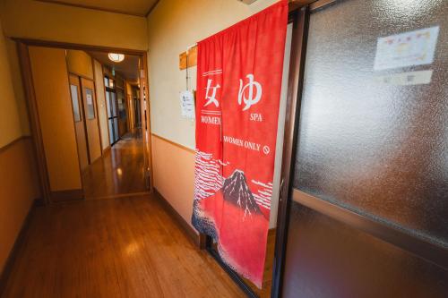 a hallway with a red banner on the wall at HOTEL LT Kitchen Yugawara in Yugawara
