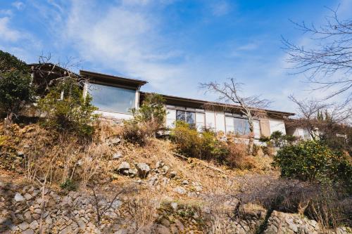 a house on the side of a hill at HOTEL LT Kitchen Yugawara in Yugawara