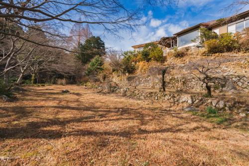 a house on top of a stone wall at HOTEL LT Kitchen Yugawara in Yugawara