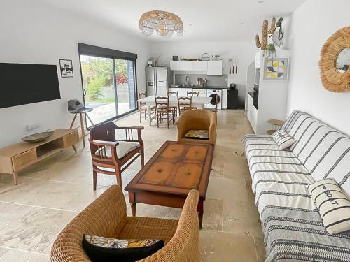 ein Wohnzimmer mit Sofa und Tisch in der Unterkunft Piscine privée proche Thalassothérapie et Mer in Pornic