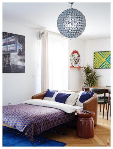 une chambre avec un lit et un lustre dans l'établissement Elegant 4 pieces avec 2 Parking à 20 min de Paris et Disney, à Villiers-sur-Marne