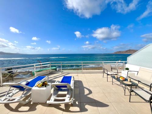 Un balcón con sillas y vista al mar. en Canteras Vista del Mar, en Las Palmas de Gran Canaria