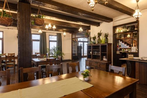 a dining room with wooden tables and chairs at Pensiunea Csató Borzont - Csató Panzió Borzont in Borzont