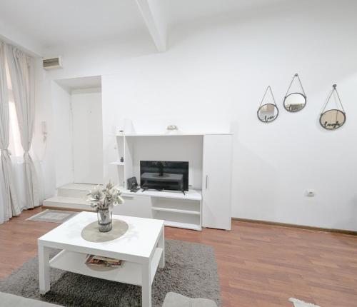 a white living room with a table and a fireplace at Central Peaceful Nest Belgrade in Belgrade