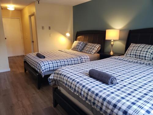 a bedroom with two beds with a blue and white checkered sheets at Beverly Hills Studios in Los Angeles