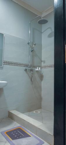 a shower with a glass door in a bathroom at Luxe City Stays by Daph in Buwate
