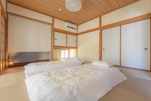 a bedroom with two white beds in it at ドッグラン付きのプライベート宿伊豆月ヶ瀬修善寺RVillage in Izu