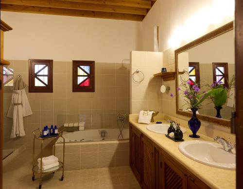 a bathroom with a sink and a tub and a mirror at Aquagrand Artistic Luxury Beach Resort - Adults Only in Líndos