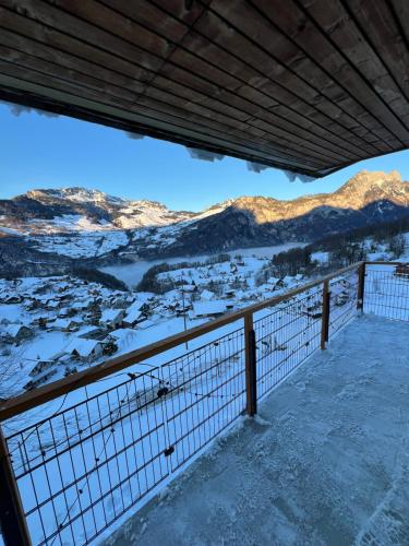 a view of a snowy mountain range from a balcony at Mürtschen Lodge in Filzbach