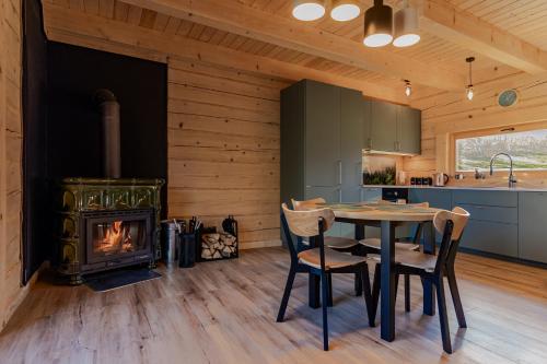 a kitchen and dining room with a table and a fireplace at zDrzewaDom in Skrzydlna