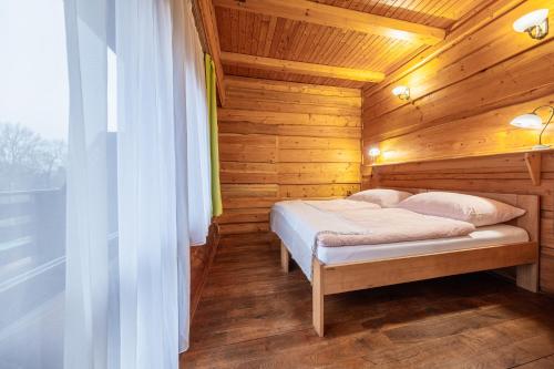 a bedroom with a bed in a wooden cabin at Sport-hotel Šibeniční vrch in Mnichovice