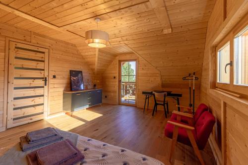a room with a bed and a table in a cabin at zDrzewaDom in Skrzydlna