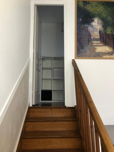 a stairway leading to a hallway with a painting at Maison 10min Roissy CDG in Mitry-Mory