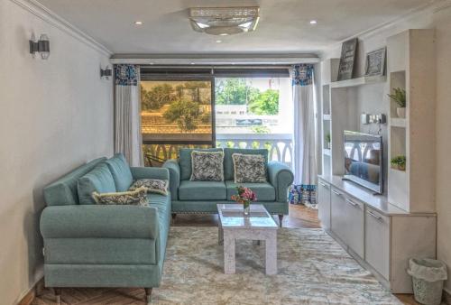 a living room with a blue couch and a table at Casa Marabella in Diani Beach