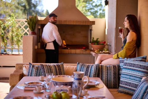 two people sitting on a couch in front of a fireplace at Aquagrand Artistic Luxury Beach Resort - Adults Only in Líndos
