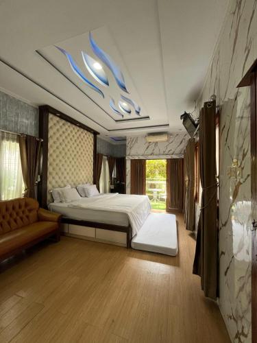 Un dormitorio grande con una cama y un sofá. en Residence Rafitha, en Yogyakarta