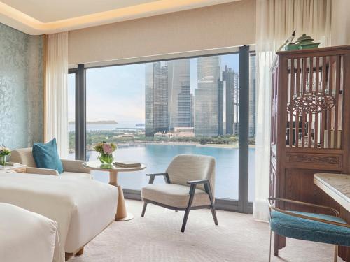 a bedroom with a bed and a view of the city at Mandarin Oriental, Singapore in Singapore