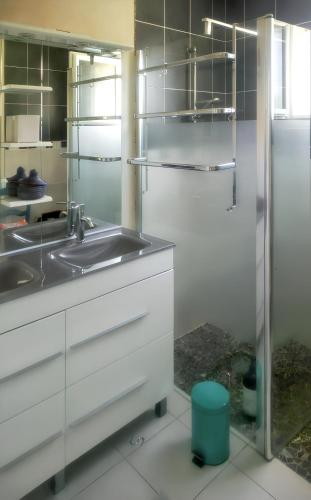 une cuisine avec des armoires blanches et un évier dans l'établissement Maison charmante à Mimizan avec vue sur jardin et terrasses, à Mimizan