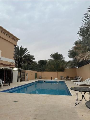 a large swimming pool in a resort with a table at Al Ain Hotel Apartment Family Stay with Balcony and Pool Access in Al Ain