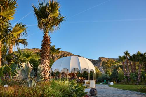 a dome tent in a garden with palm trees at Aquagrand Artistic Luxury Beach Resort - Adults Only in Líndos