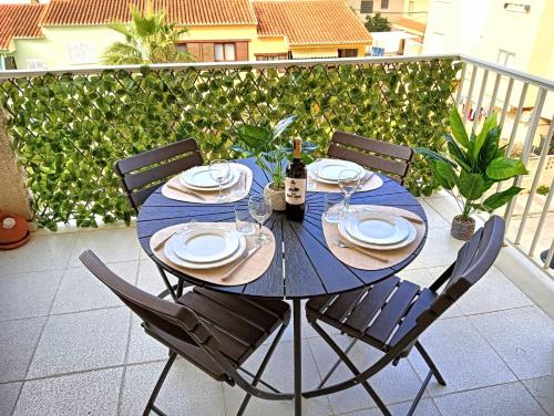 a blue table with chairs and a bottle of wine at Playa Daimus 100 m del Mar Piscina Parking in Daimuz