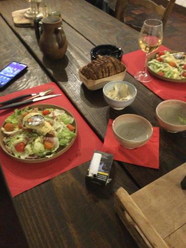 a wooden table with a plate of food on it at Auberge Gordonienne in Saint-Satur