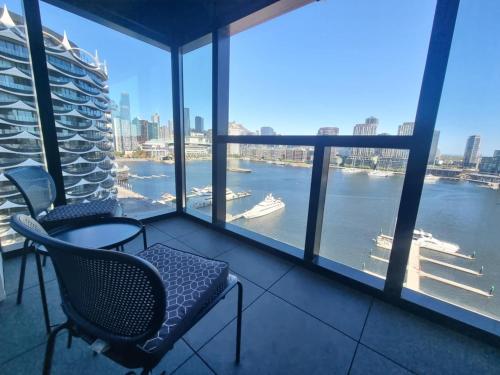 a balcony with chairs and a view of the water at Marina Tower - Stunning Harbour & City View in Melbourne