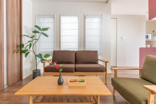 a living room with a couch and a table at 超值特惠 無料駐車 4ldk戸建 関空 難波 心斎橋 通天閣 スパワールド世界の大温泉 天王寺動物園 京都直通 現代的で広々とした空間に和風の魅力とプライベート庭園を融合した豪華な別荘 in Osaka