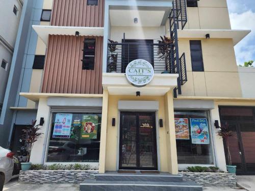 a building with a cafe sign on the front of it at Ralik Hostel in Naga
