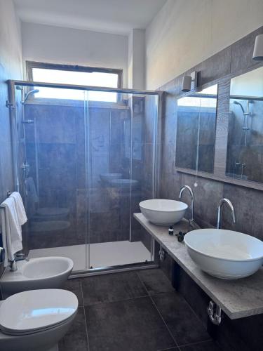 a bathroom with two sinks and a shower at Hotel La Magione in Poggibonsi