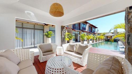 a living room with white furniture and a pool at Paradise in the Heart of Mauritius in Grand Baie