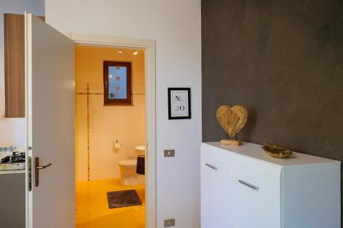 a bathroom with a white refrigerator and a toilet at Casa Salea in Castelveccana