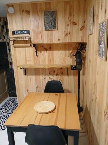 une chambre avec une table en bois et deux chaises dans l'établissement Les quatres saisons de isa, à Dole