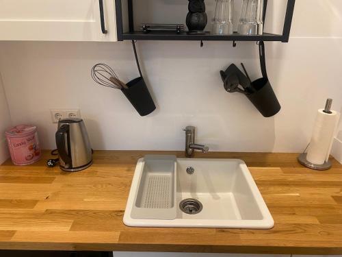 a kitchen sink sitting on a wooden counter top at Skyview Suite I modern I kontaktloser Check-in I Business I Kurztrips I nachhaltig in Bad Dürrheim